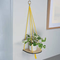 Kleine plantenplank met geel touw van Studio Wald, tegen de muur
