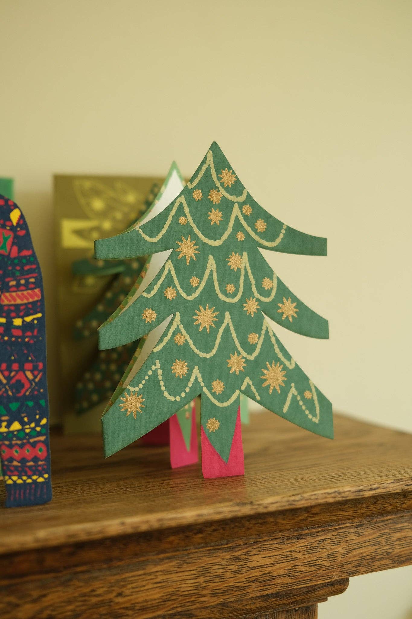 Uitgevouwen harmonicakaart met rijkgekleurde kerstboom