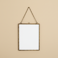 Hangende fotolijst verouderd messing 20x25 cm op warme beige achtergrond, studiofoto