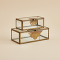 Glazen doosjes met messing blad set van 2 op warme beige achtergrond, studiofoto