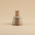 Handgemaakte flessenstop bruin/gebroken wit op warme beige achtergrond, studiofoto