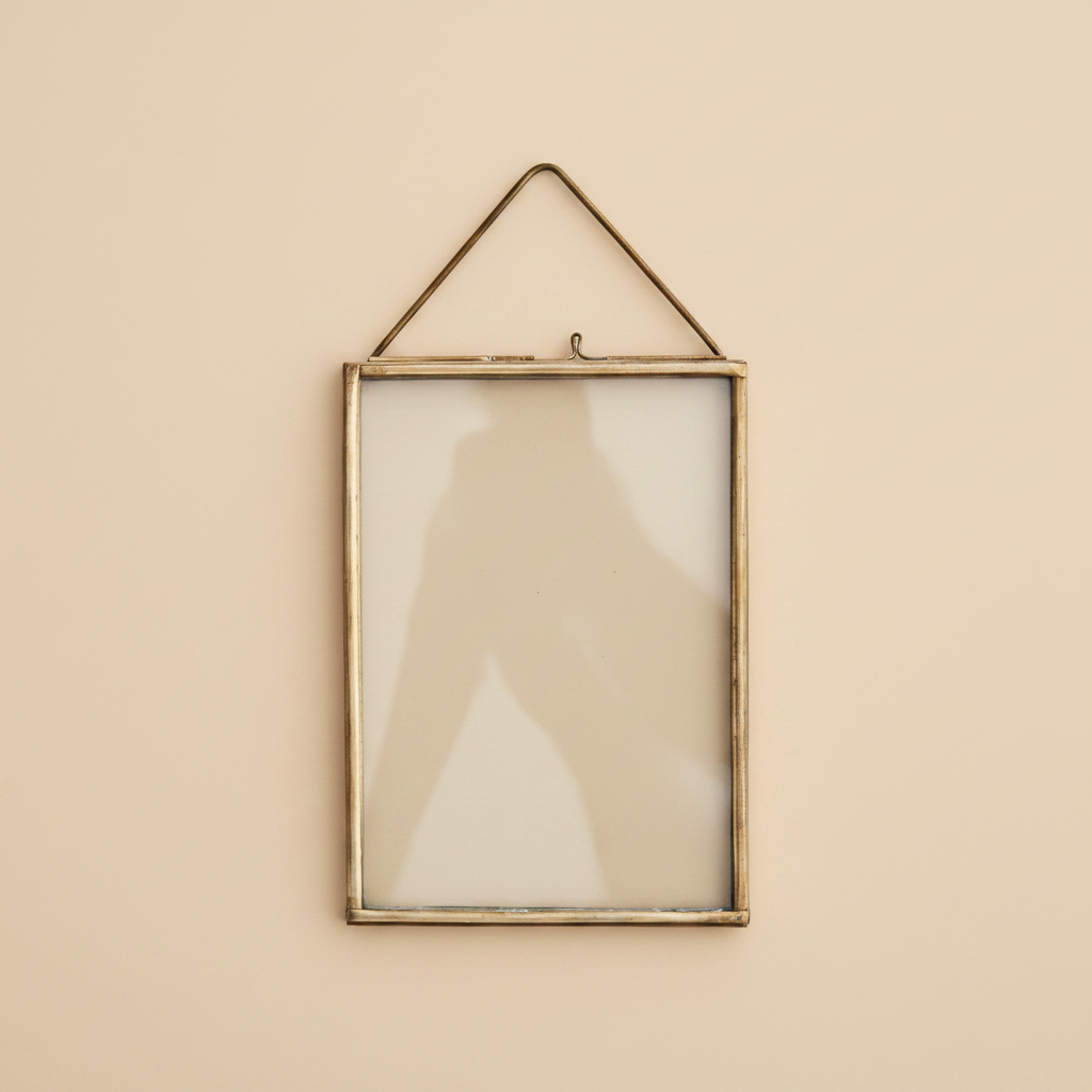Hangende fotolijst verouderd messing 13x18 cm op warme beige achtergrond, studiofoto