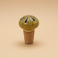 Handbeschilderde flessenstop mosterd op warme beige achtergrond, studiofoto