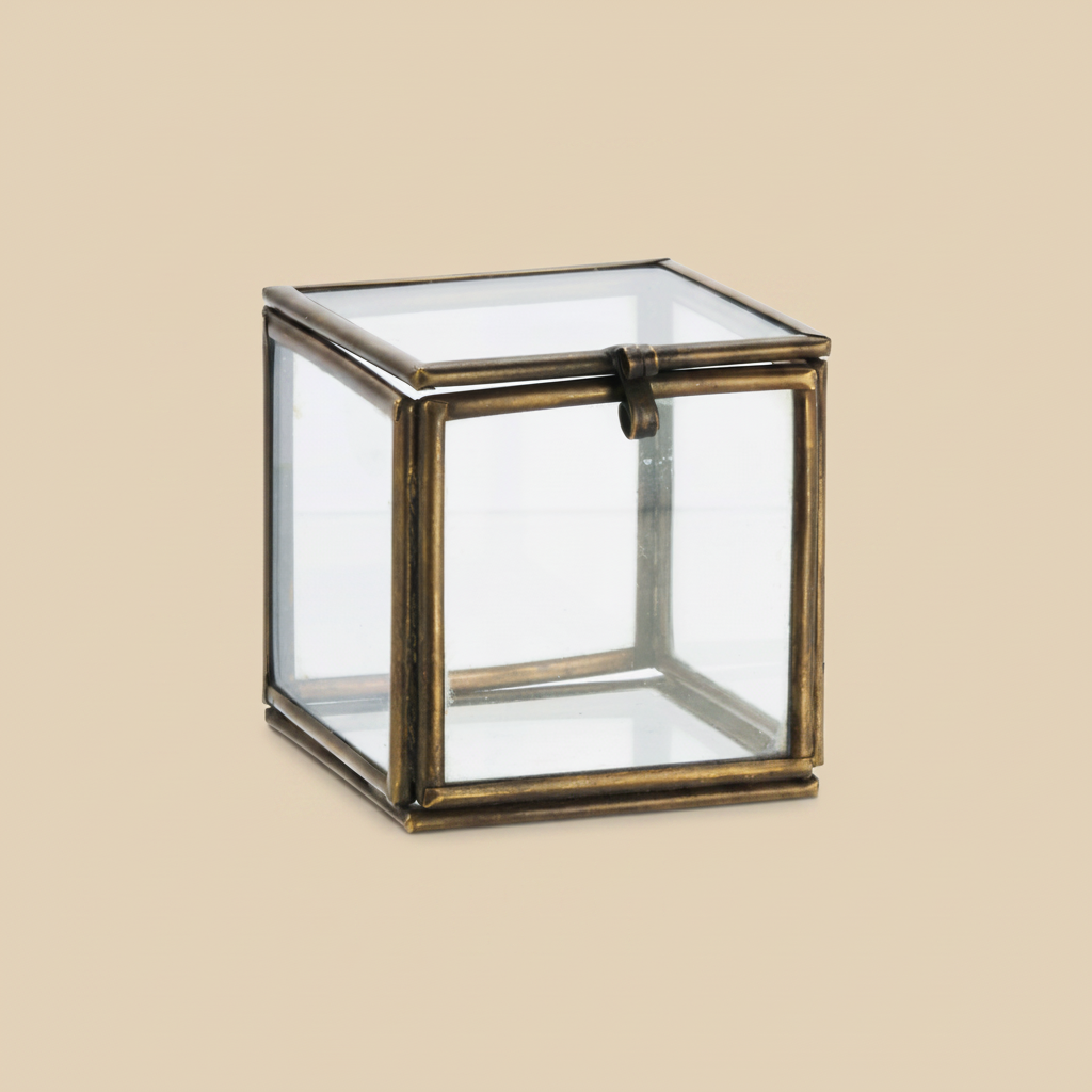 Glazen doosje verouderd messing 5x5x5 cm op warme beige achtergrond, studiofoto