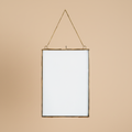 Hangende fotolijst antiek messing 21x29,5 cm op warme beige achtergrond, studiofoto