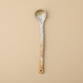 Stenen serveerlepel mosterd/perzik op warme beige achtergrond, studiofoto