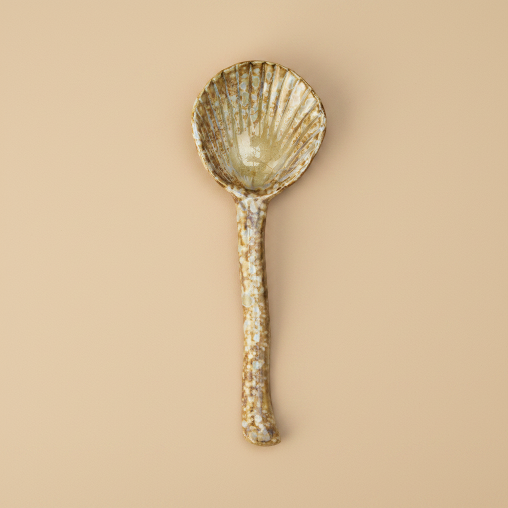 Stenen serveerlepel bruin/beige op warme beige achtergrond, studiofoto