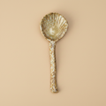 Stenen serveerlepel bruin/beige op warme beige achtergrond, studiofoto