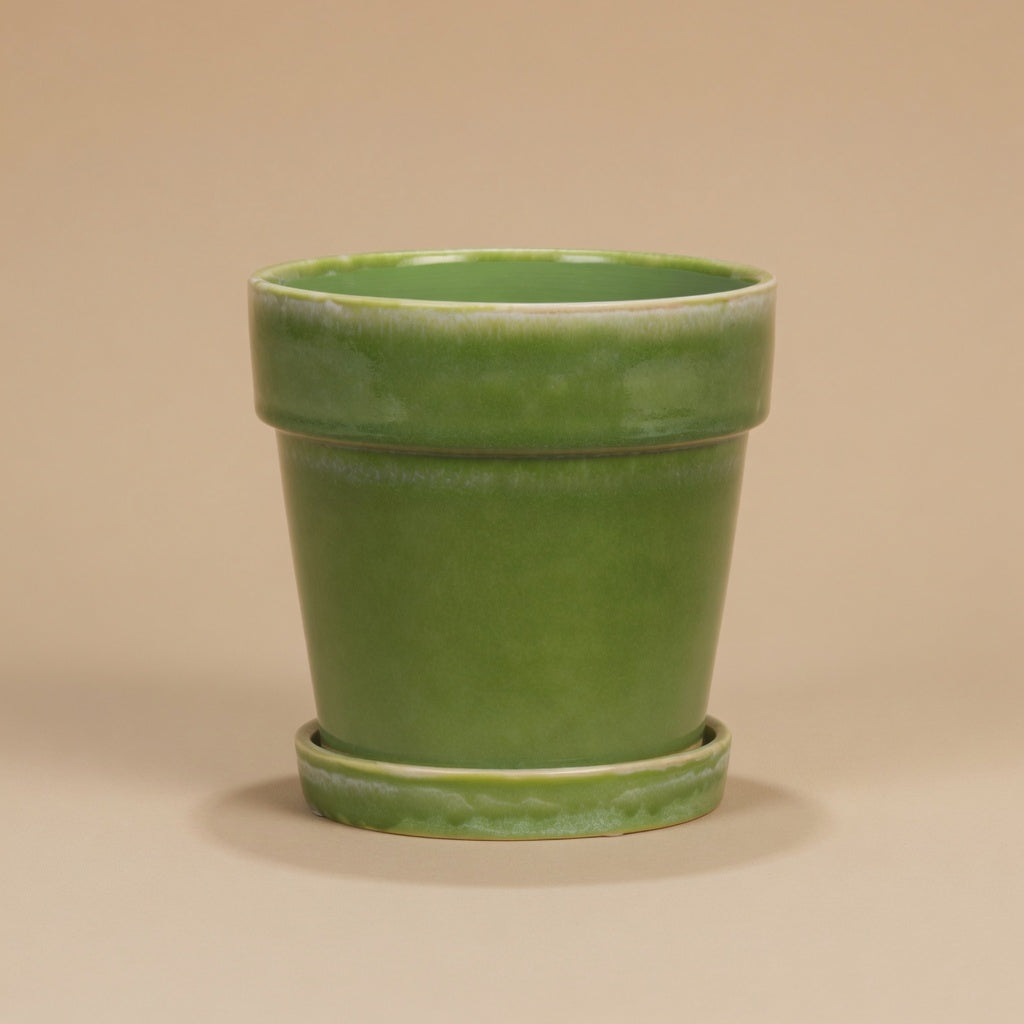 Groene bloempot met schotel, diameter 18 cm, op warme beige achtergrond, studiofoto