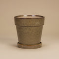 Beige bloempot met schotel, diameter 18 cm, op warme beige achtergrond, studiofoto